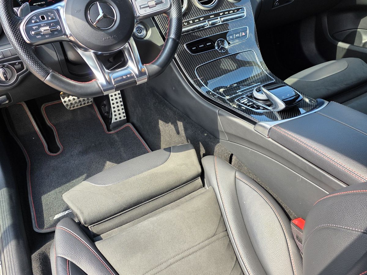 Interior Mercedes-AMG cu finisaj din fibră de carbon, volan sport și cusături roșii pe scaune